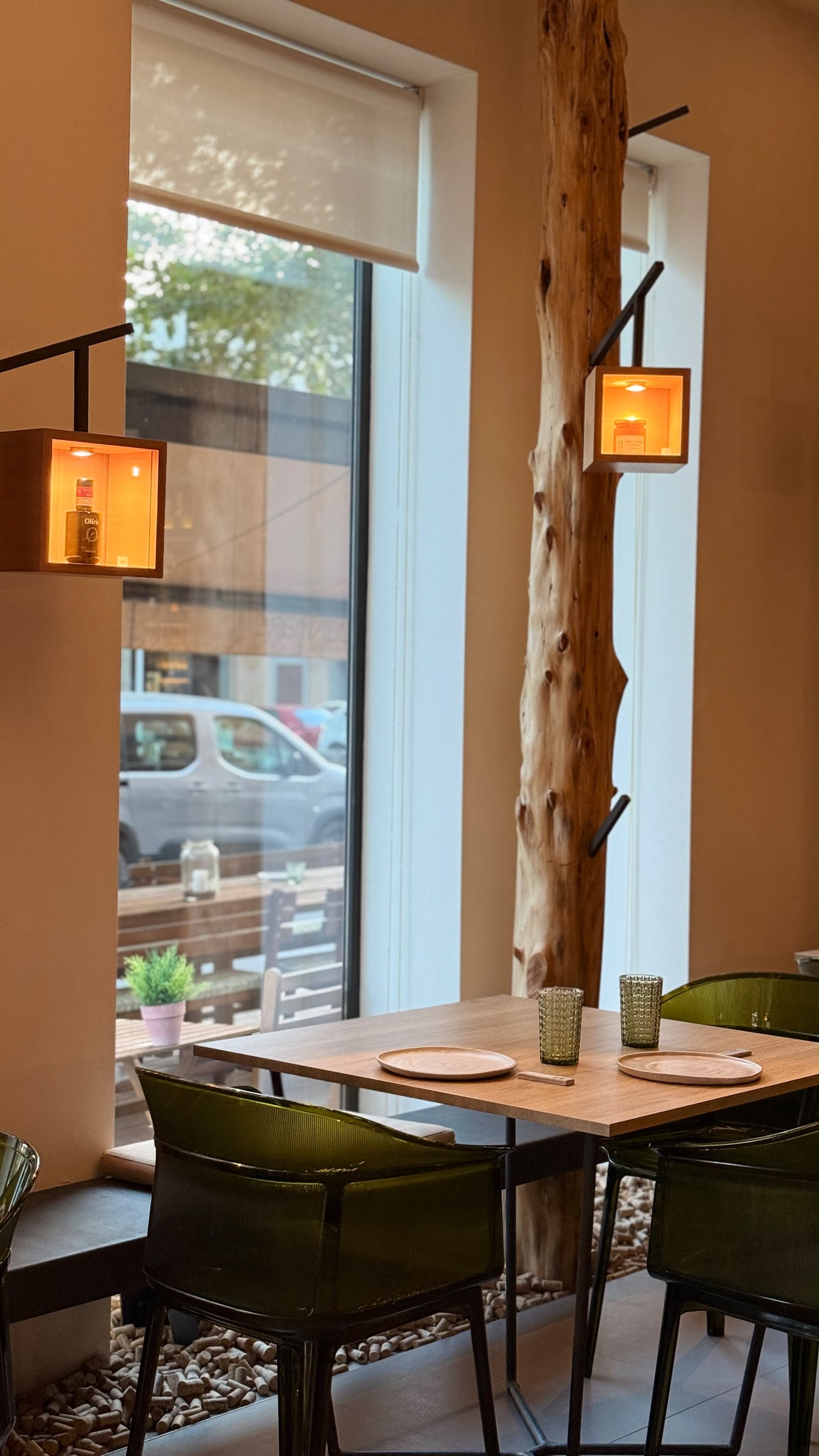 Una mesa para dos junto a la ventana y a un tronco de madera