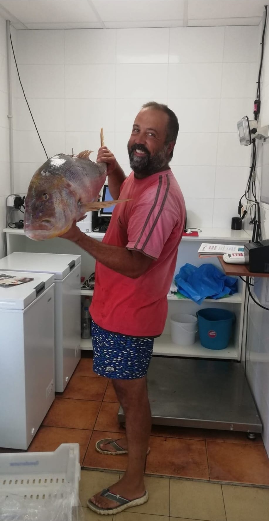 Andreu Gil con un pescado recién capturado en la lonja de Cala Bona
